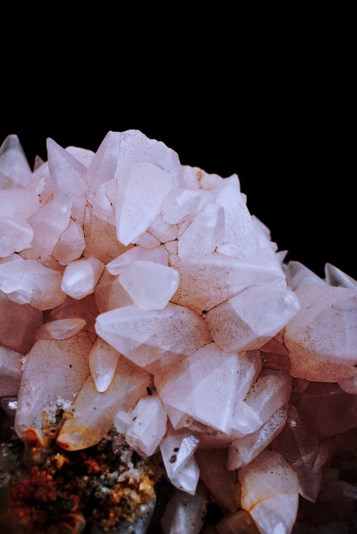 Stunning close-up of pink quartz crystals with detailed facets against a dark background.
