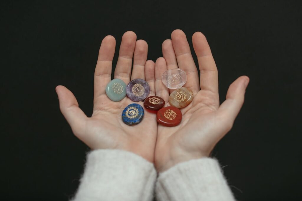 A close-up image of chakra stones held in open hands, showcasing spiritual balance.