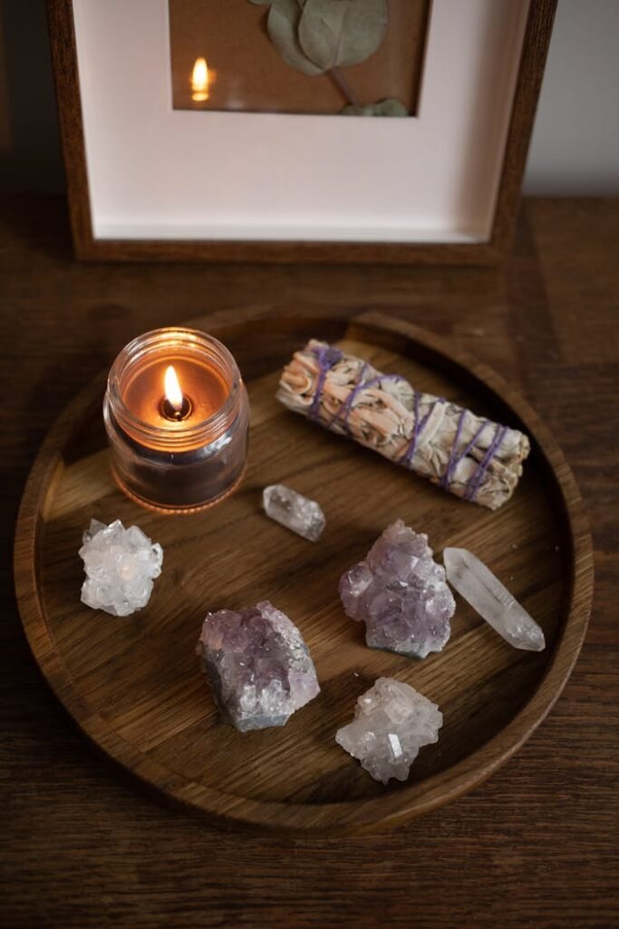 A calming scene with candles and crystals on a wooden tray, perfect for meditation or relaxation.